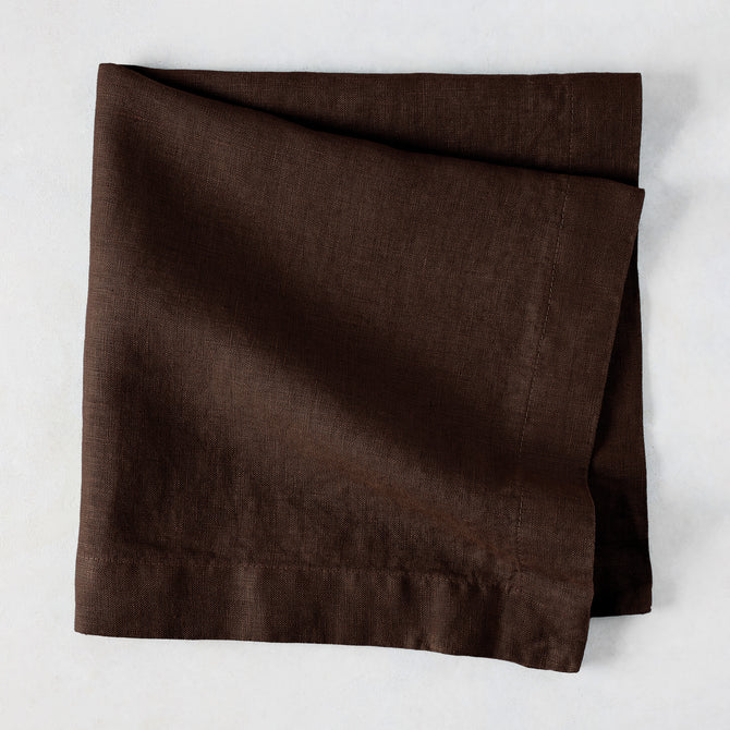 Cocoa HG hand-dyed 22" square brown linen napkin, folded on a light surface.