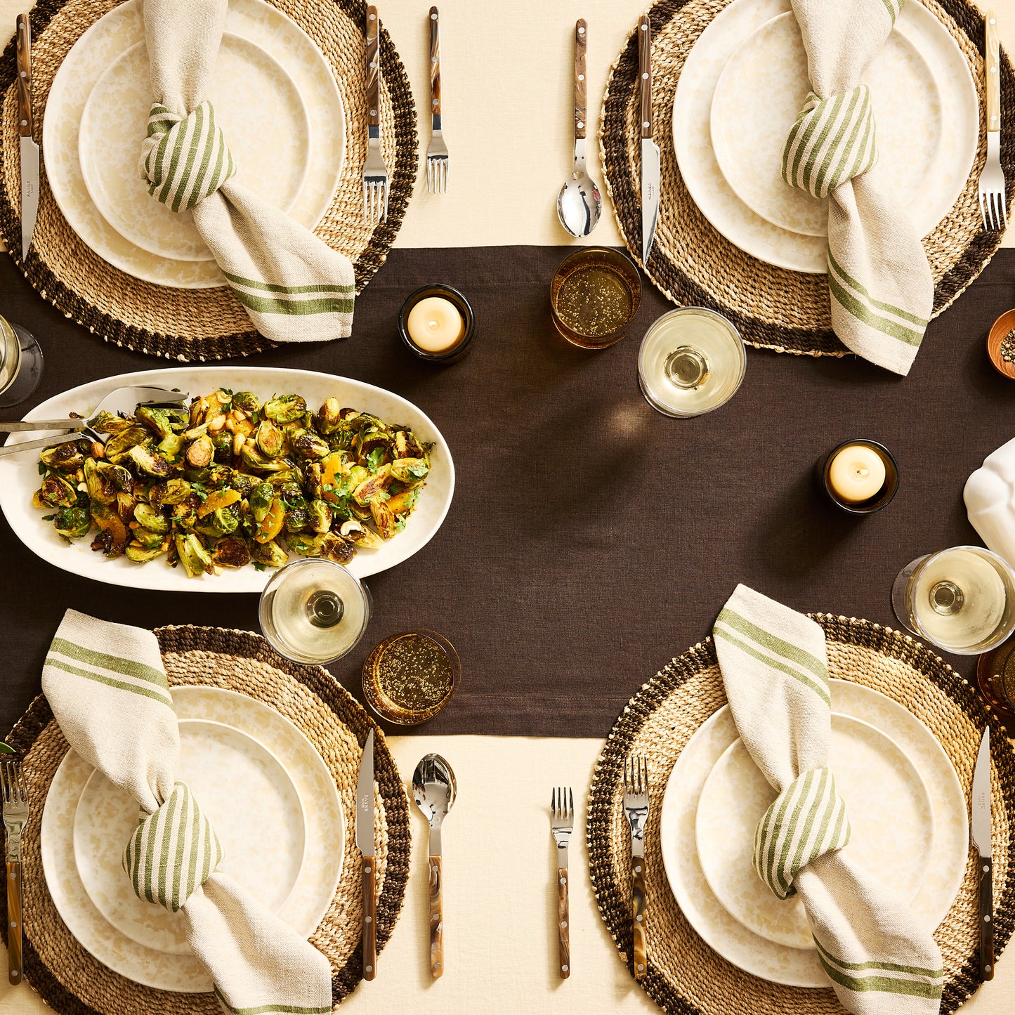 Cocoa HG hand-dyed linen table runner with four place settings, food, and drinks on a dining table.