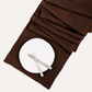 Cocoa HG hand-dyed linen table runner with a white plate and silverware, folded on a white background.