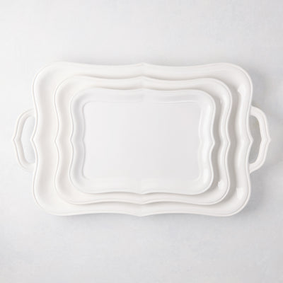 Colette white ceramic serving platters, set of 3, with scalloped edges and handles, stacked.