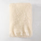 Folded cream mohair throw blanket with fringe, 72"L x 51"W.