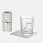 Roll of 50 cream cotton tear-off cocktail napkins with a glass of ice on one napkin.