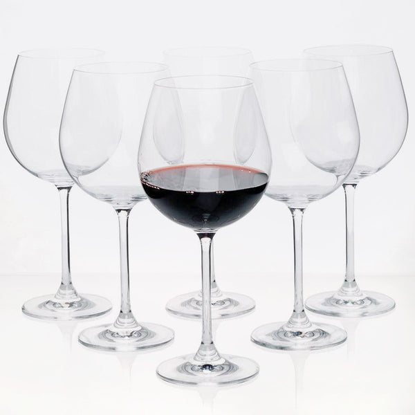 Set of 6 clear crystal Burgundy stem wine glasses, one filled with red wine.