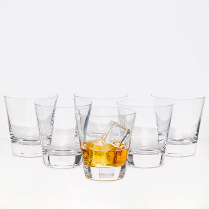 Set of 6 clear crystal whiskey glasses, one with amber liquid and ice.
