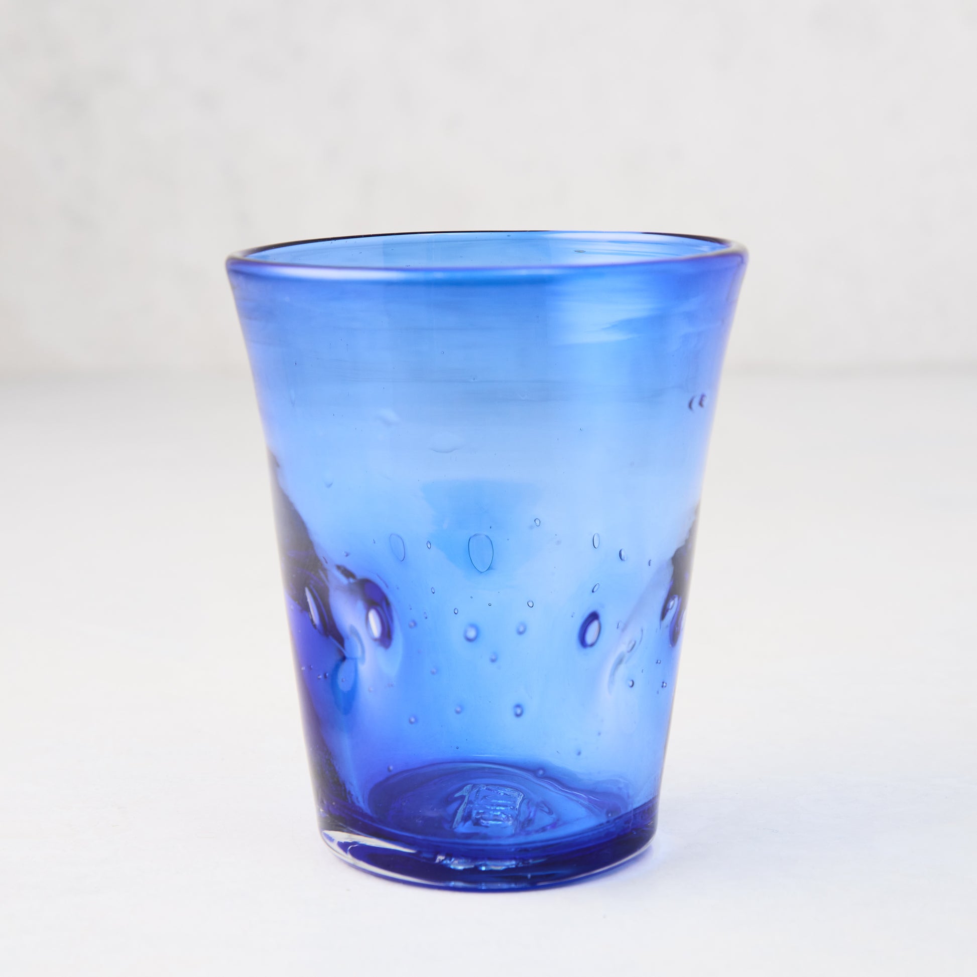 Dark blue Henri 8 oz. mouth-blown glass with unique imperfections and small air bubbles.