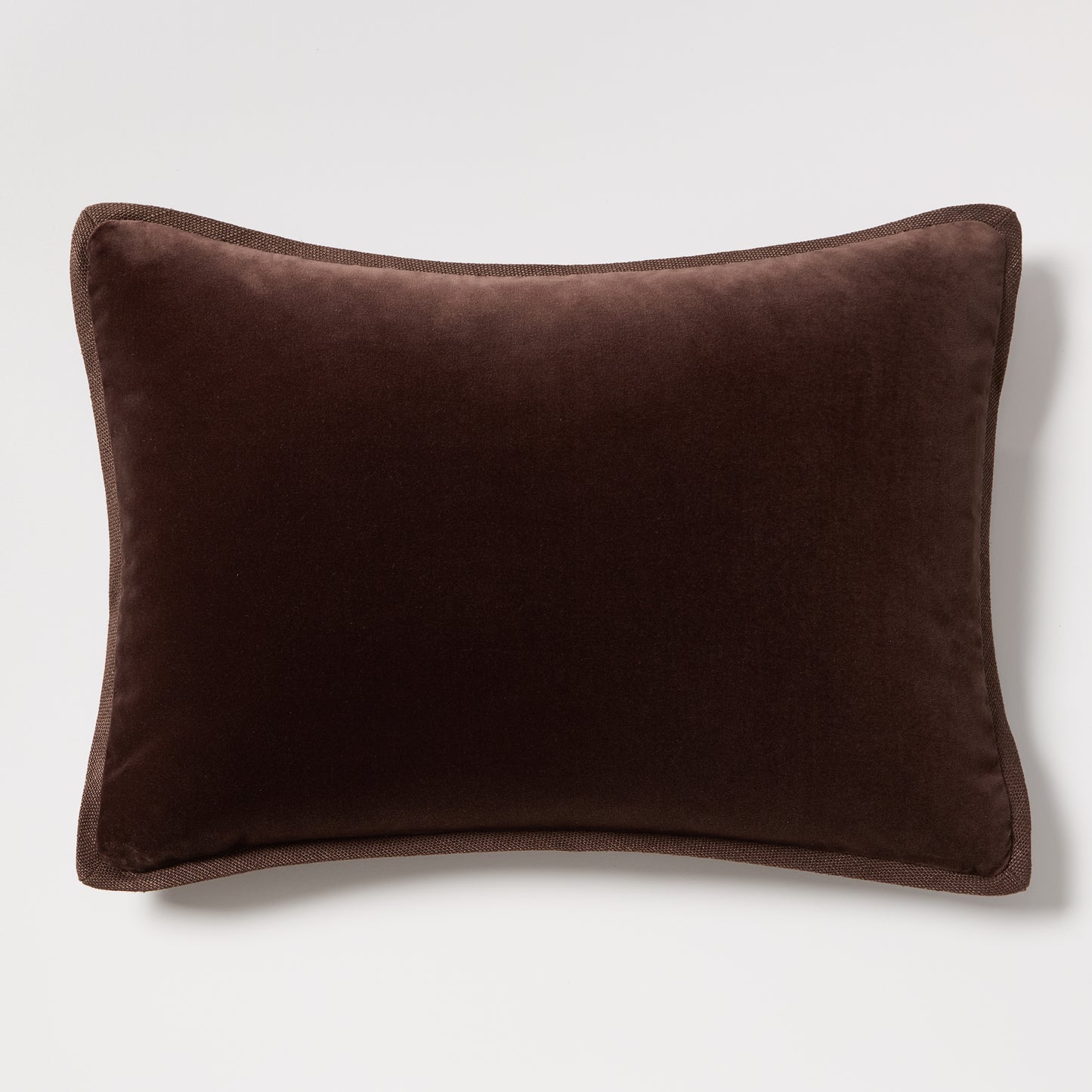 Dark brown velvet and linen reversible lumbar pillow, 20"L x 14"H, with tonal piping.