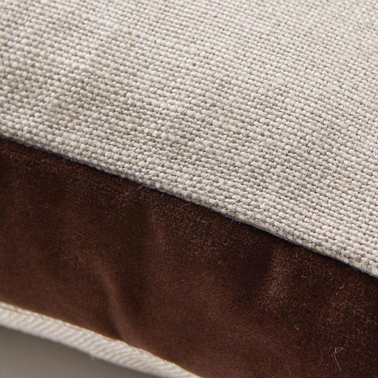 Close-up of a 22" square pillow with a dark brown velvet gusset and natural flax linen top.