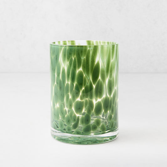 Hand-blown 12oz double old fashioned glass with dark green spots on a clear base.