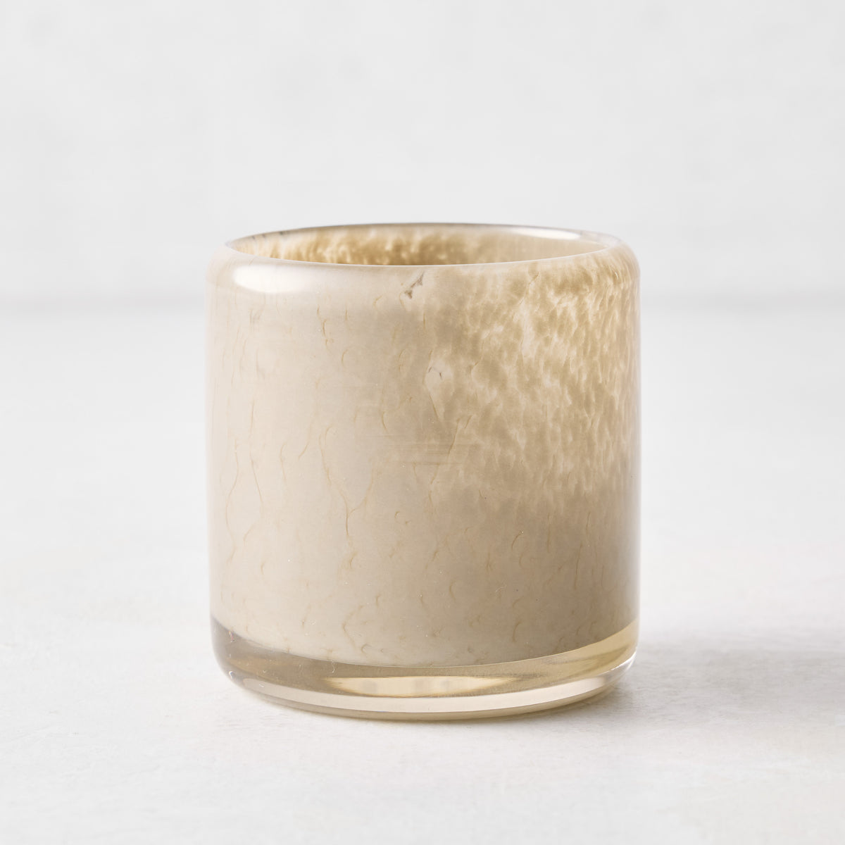 Small dark taupe mouth-blown glass votive candle holder, 2.75 inches tall with a textured, translucent finish.