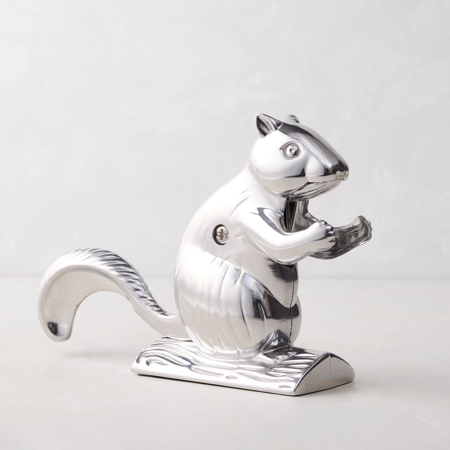 Shiny silver metal squirrel nutcracker, "Davy Crackit" design, on a light gray surface.