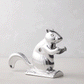 Shiny silver metal squirrel nutcracker, "Davy Crackit" design, holding a nut, on a light background.
