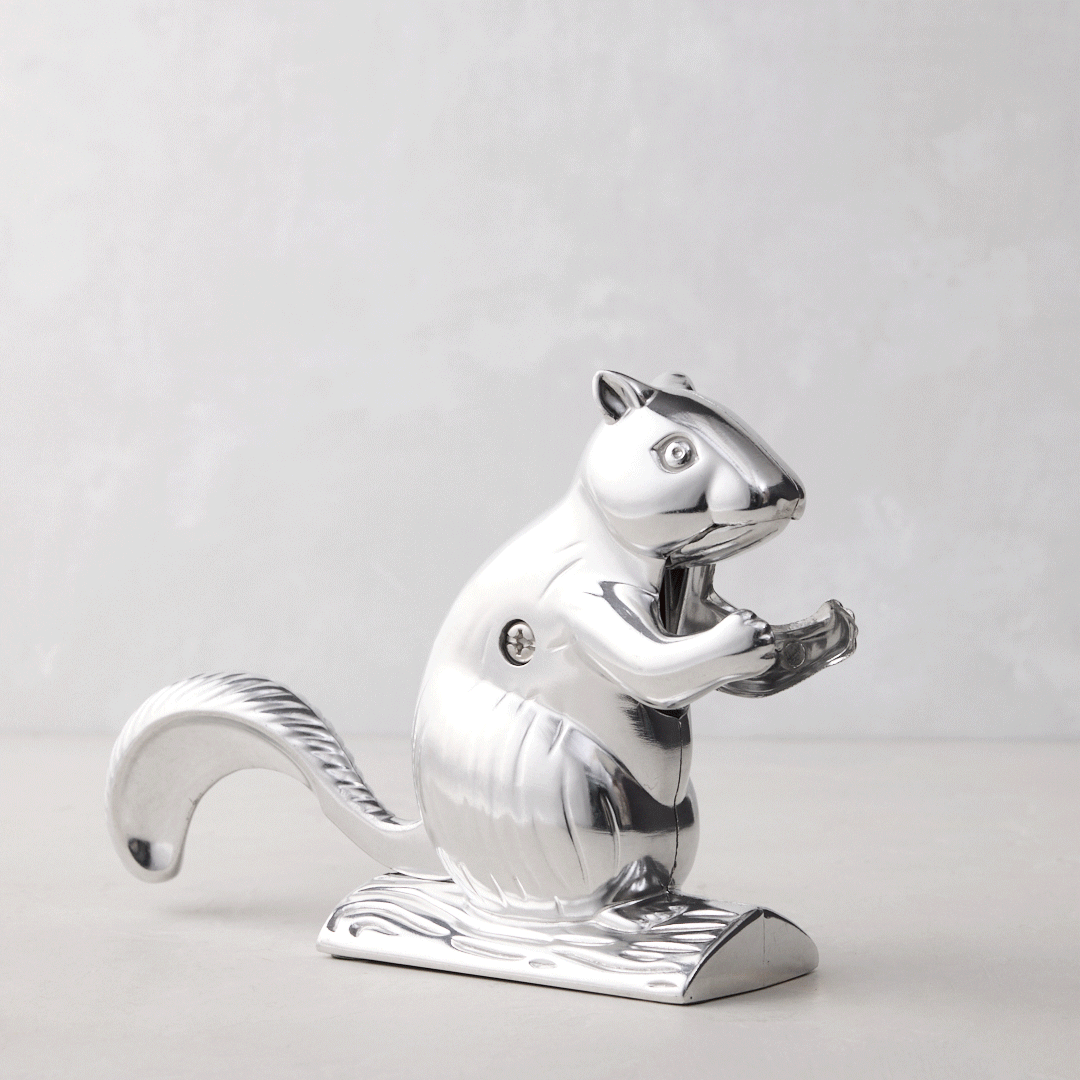 Shiny silver metal squirrel nutcracker, "Davy Crackit" design, holding a nut, on a light background.