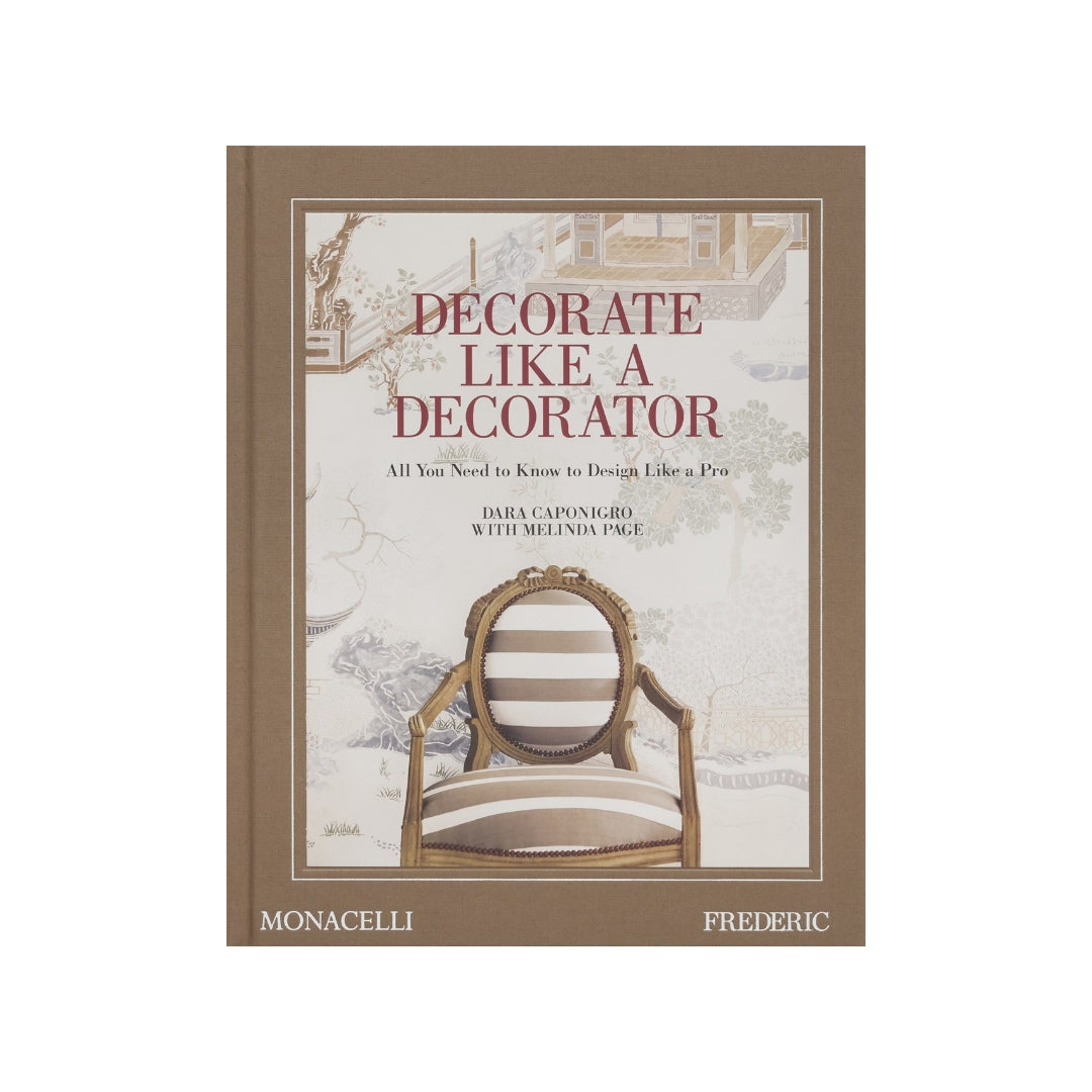 Hardcover book "Decorate Like a Decorator" with a brown spine and a cover featuring a striped chair against a scenic wallpaper.
