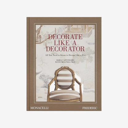 Hardcover book "Decorate Like a Decorator" with a brown spine and a cover featuring a striped chair against a scenic wallpaper.
