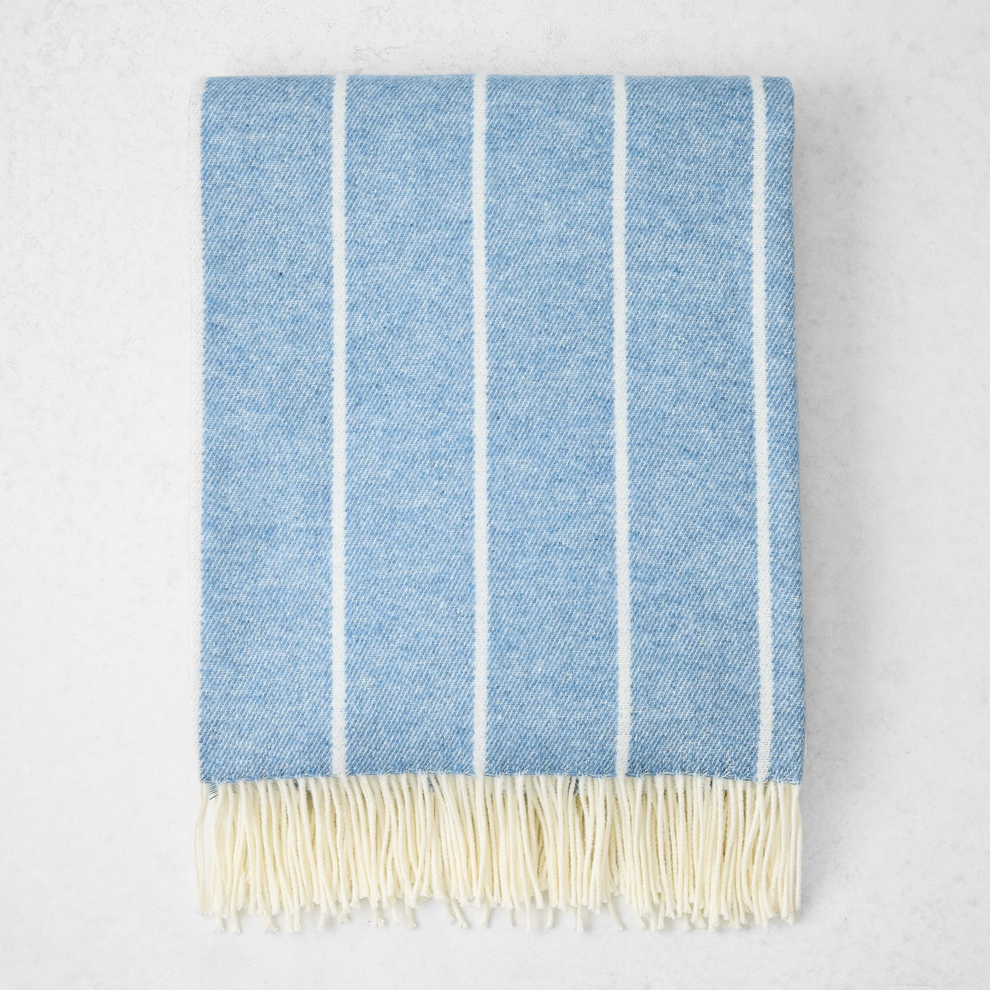 Denim Blue Fiji Stripe Throw Blanket, 51"x67" cotton-acrylic, with white vertical stripes and fringe.