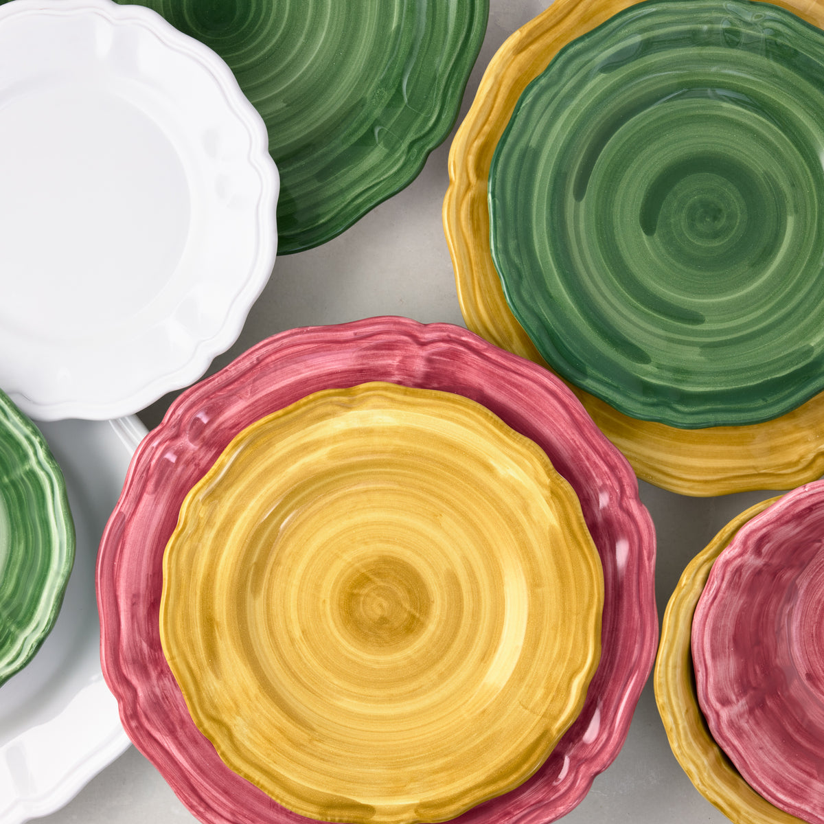 Hand-painted 11-inch ceramic dinner plates with scalloped edges in white, green, yellow, and pink.