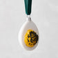 2.75-inch glass deviled egg Christmas ornament with a yellow yolk, black caviar detail, and green velvet ribbon.