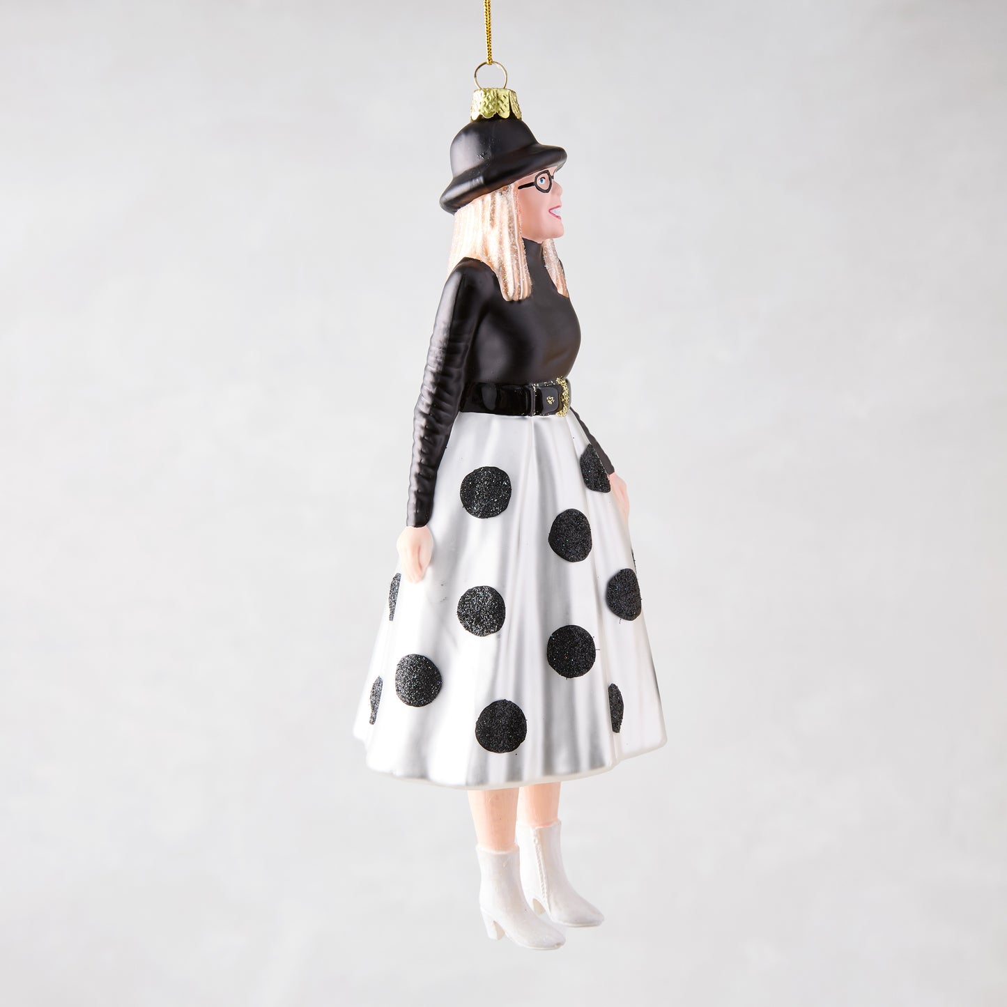 Diane Keaton Christmas tree ornament, black hat, glasses, black top, white polka dot skirt, white boots.