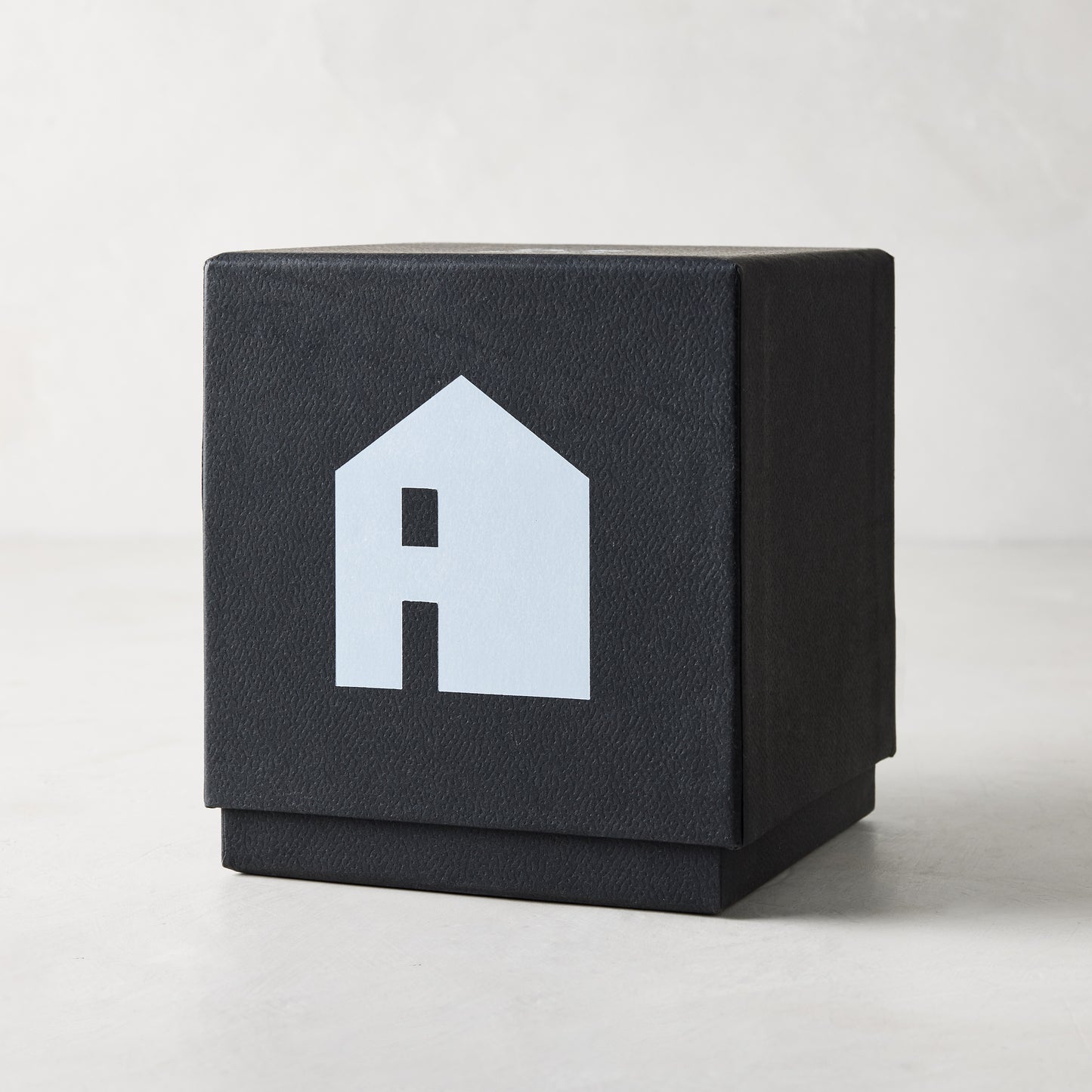 Diane Keaton "HOUSE" scented candle in a sleek black gift box with a white house logo.