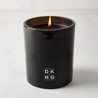 Diane Keaton x Hudson Grace "HOUSE" scented candle in a sleek black glass vessel with a burning wick.