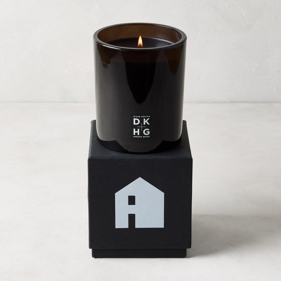 Diane Keaton x Hudson Grace "HOUSE" scented candle in a sleek black glass vessel on a black gift box with a house logo.