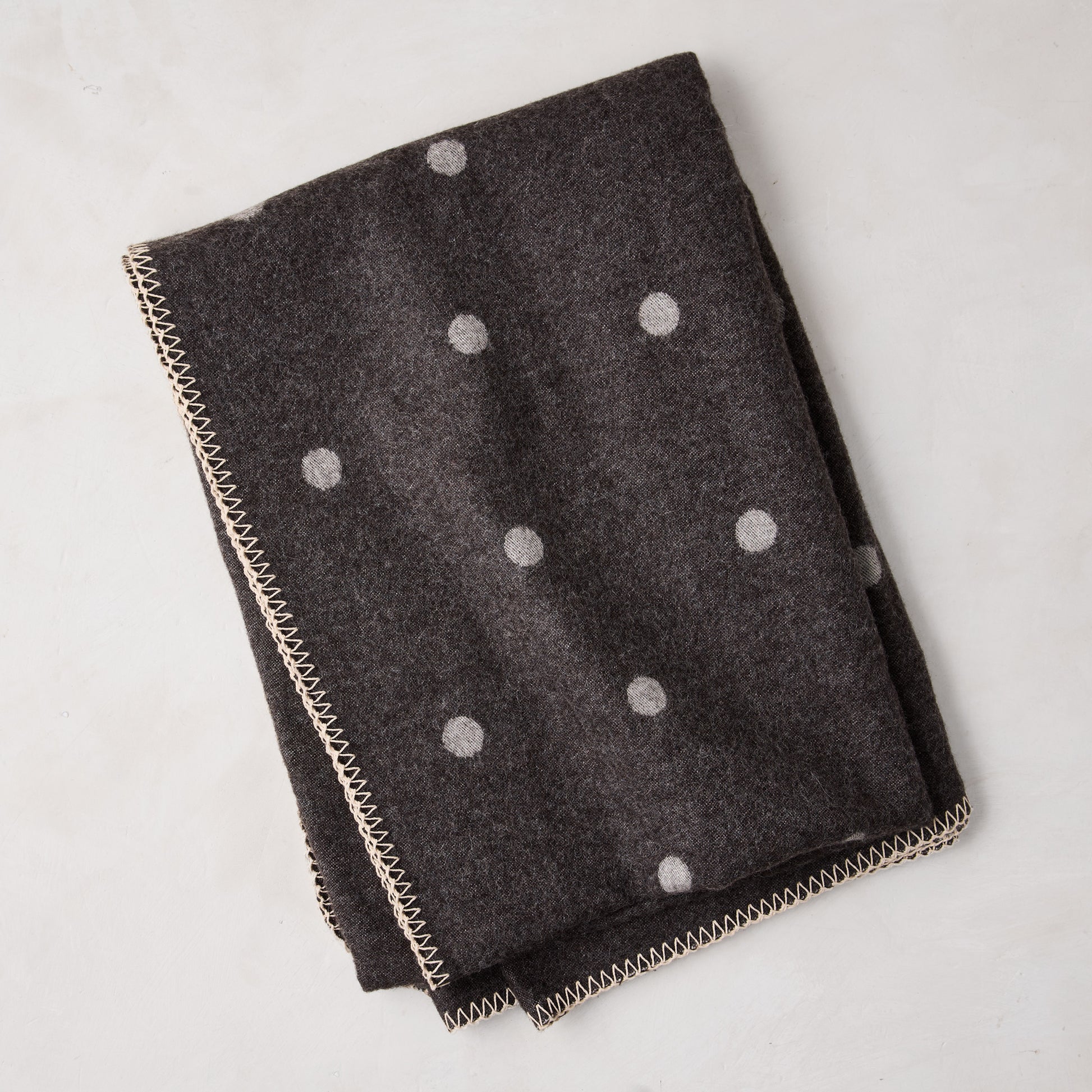 Diane Keaton + Hudson Grace grey polka dot baby alpaca throw blanket with decorative stitching.