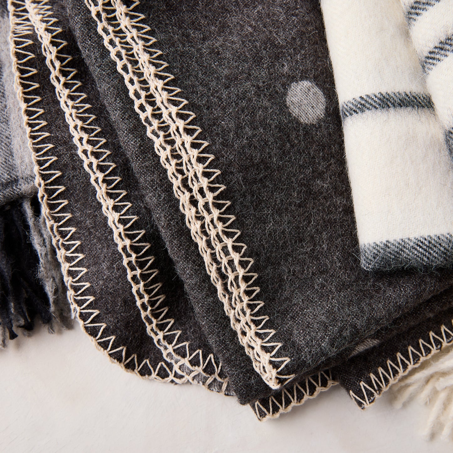 Diane Keaton + Hudson Grace grey polka dot baby alpaca throw blanket with decorative stitching.