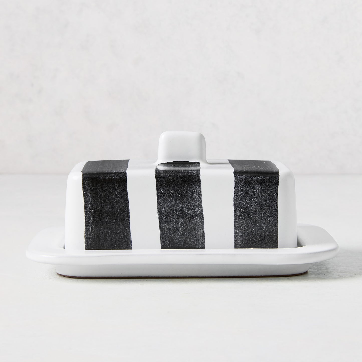Diane Keaton + Hudson Grace white stoneware butter dish with hand-painted black stripes and lid handle.