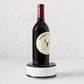 Diane Keaton + Hudson Grace black and white dipped ceramic wine coaster with a wine bottle.