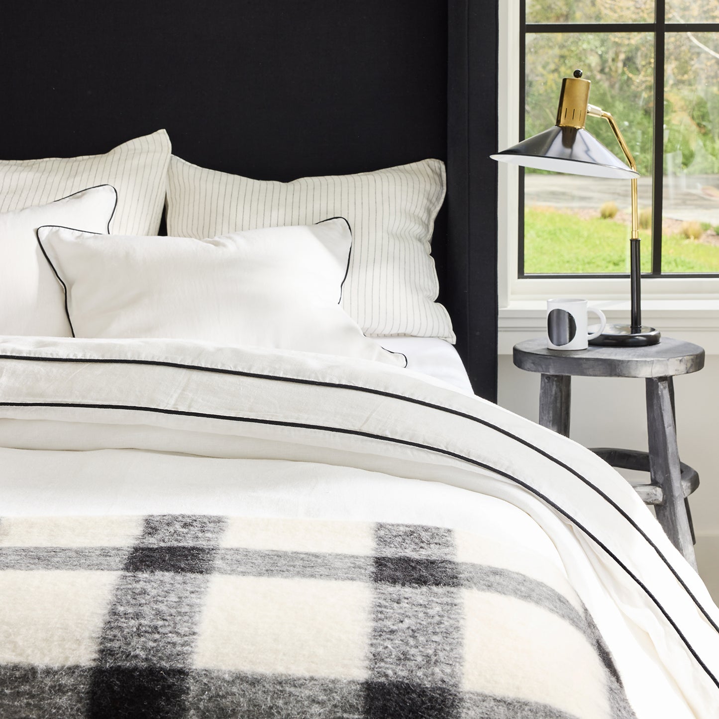 Diane Keaton + Hudson Grace black and white buffalo check alpaca throw blanket on a bed.