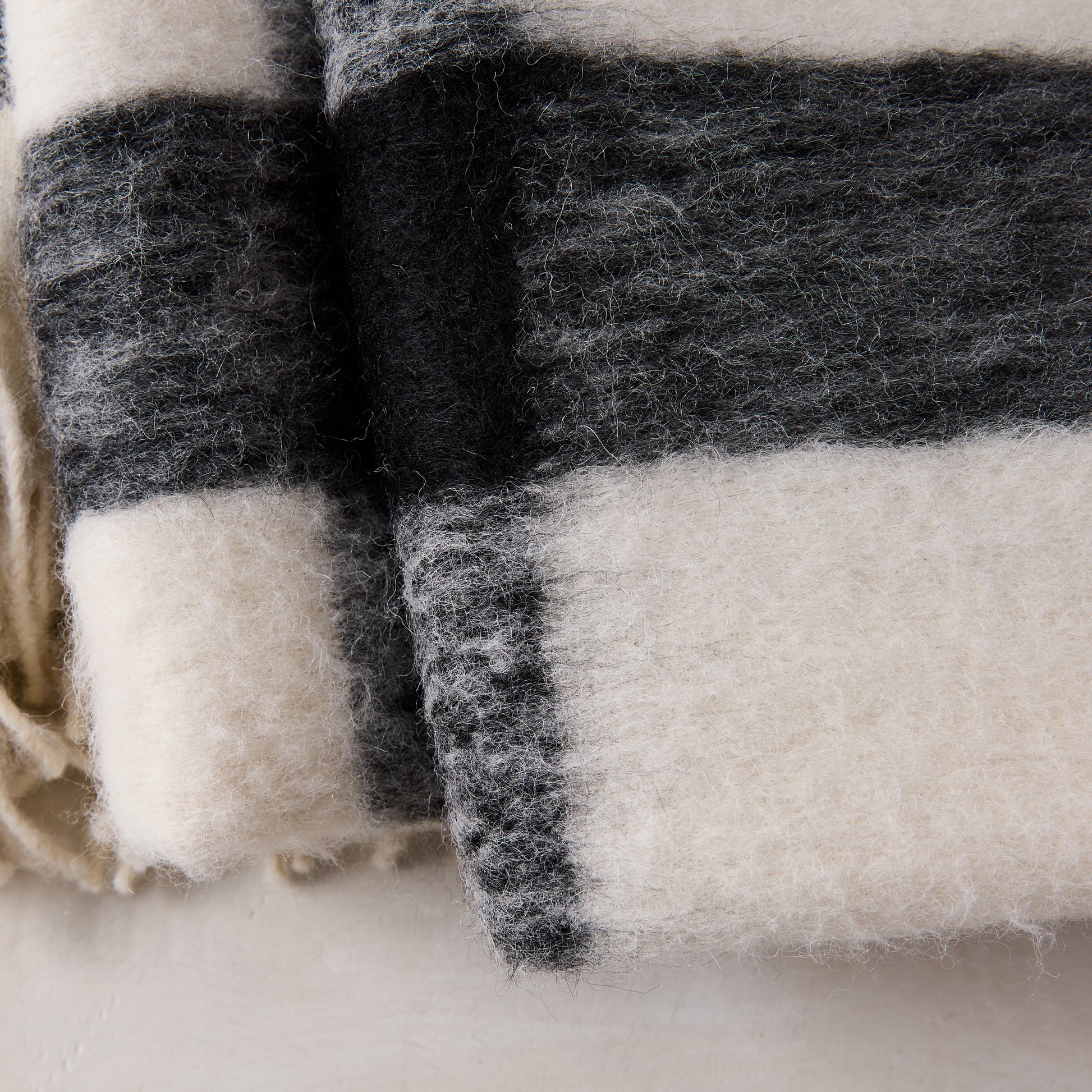 Diane Keaton + Hudson Grace black and white buffalo check alpaca throw blanket with eyelash fringe.