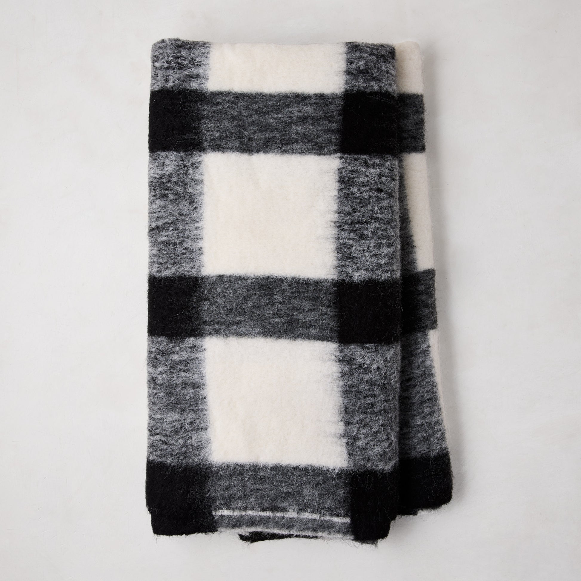 Diane Keaton + Hudson Grace black and white buffalo check alpaca throw blanket, folded.