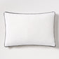 Diane Keaton + Hudson Grace white linen lumbar pillow with black gusseted trim.