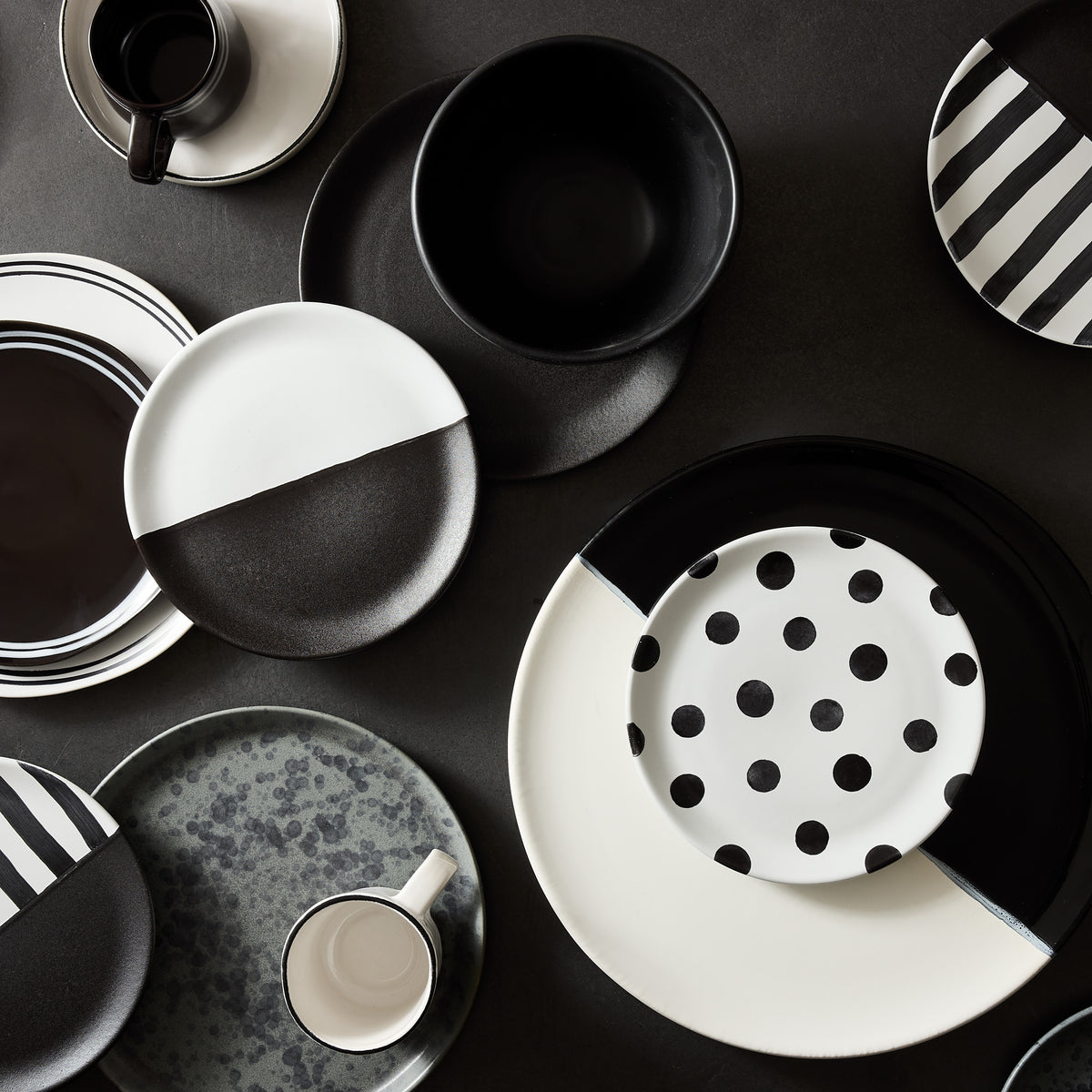 Diane Keaton x Hudson Grace stoneware dinnerware set in matte black and white with polka dot and striped patterns.