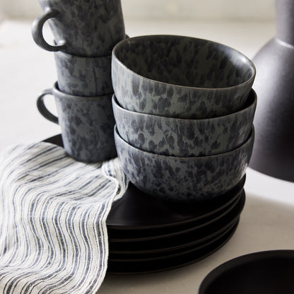 Diane Keaton + Hudson Grace Composition Splatter Stoneware Bowl, black and grey, stacked with matching dinnerware.