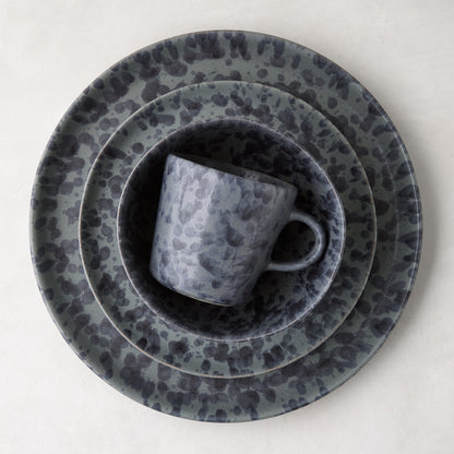 Diane Keaton + Hudson Grace black and grey splatter stoneware mug nested in matching plates.