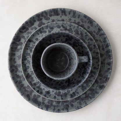 Diane Keaton + Hudson Grace black and grey splatter stoneware mug nested in matching plates.