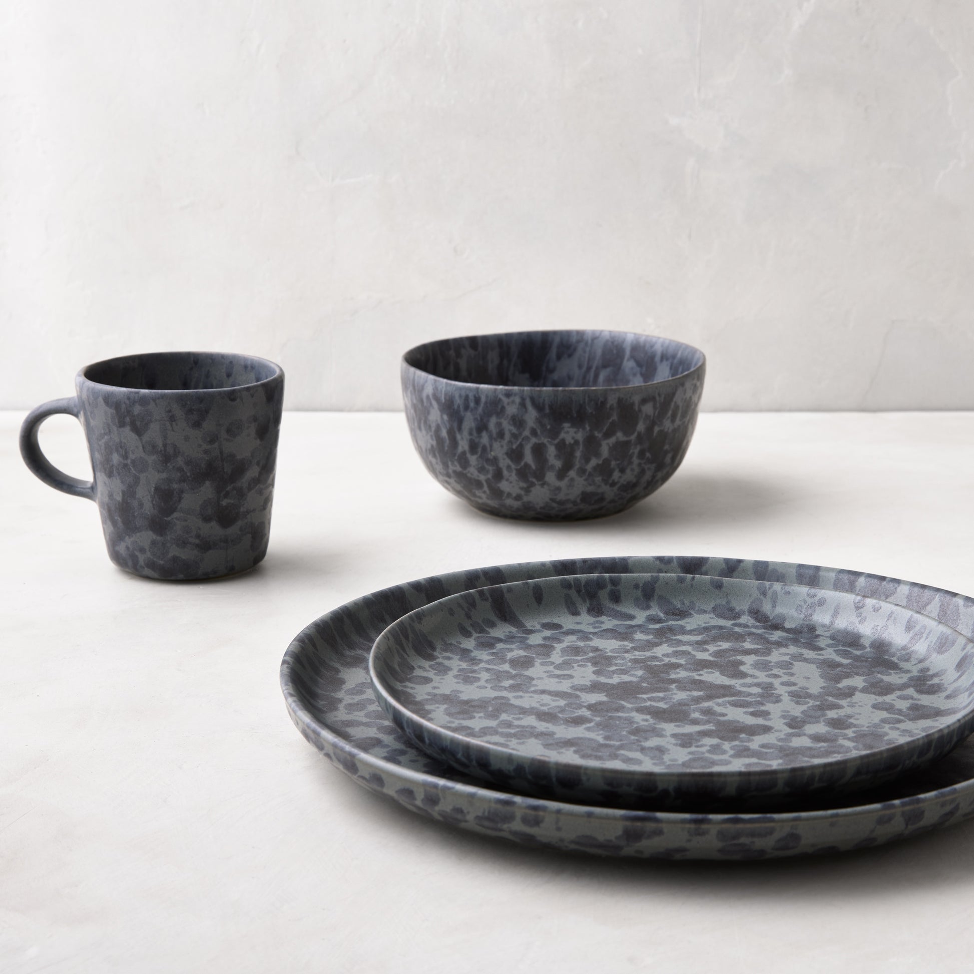 Diane Keaton + Hudson Grace black and grey splatter stoneware mug, bowl, and plates.
