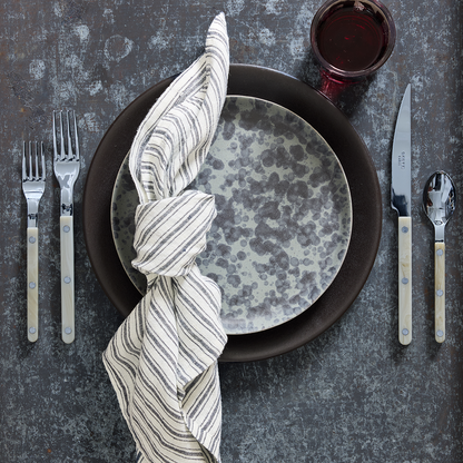 Diane Keaton x Hudson Grace stoneware salad plate with black and grey composition splatter pattern on a table setting.