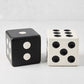 Two Diane Keaton + Hudson Grace decorative carved mango wood dice: one black with white dots, one white with black dots.