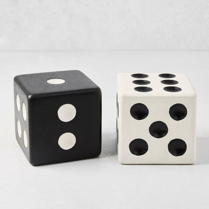 Two Diane Keaton + Hudson Grace decorative carved mango wood dice: one black with white dots, one white with black dots.