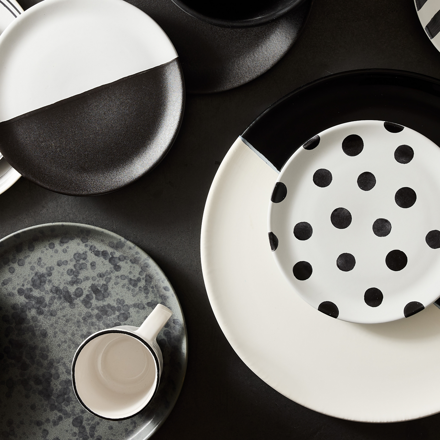Diane Keaton + Hudson Grace ceramic serving platter with a black and white half-dipped design on a dark surface.