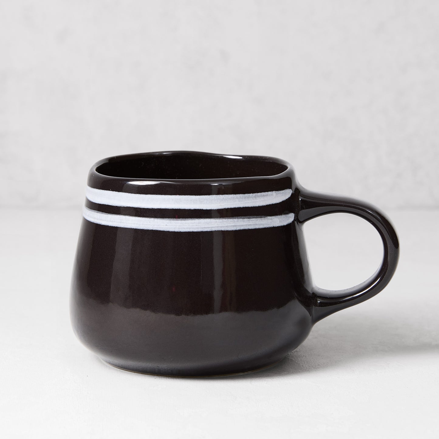 Diane Keaton + Hudson Grace Draft black stoneware mug with white double stripes.