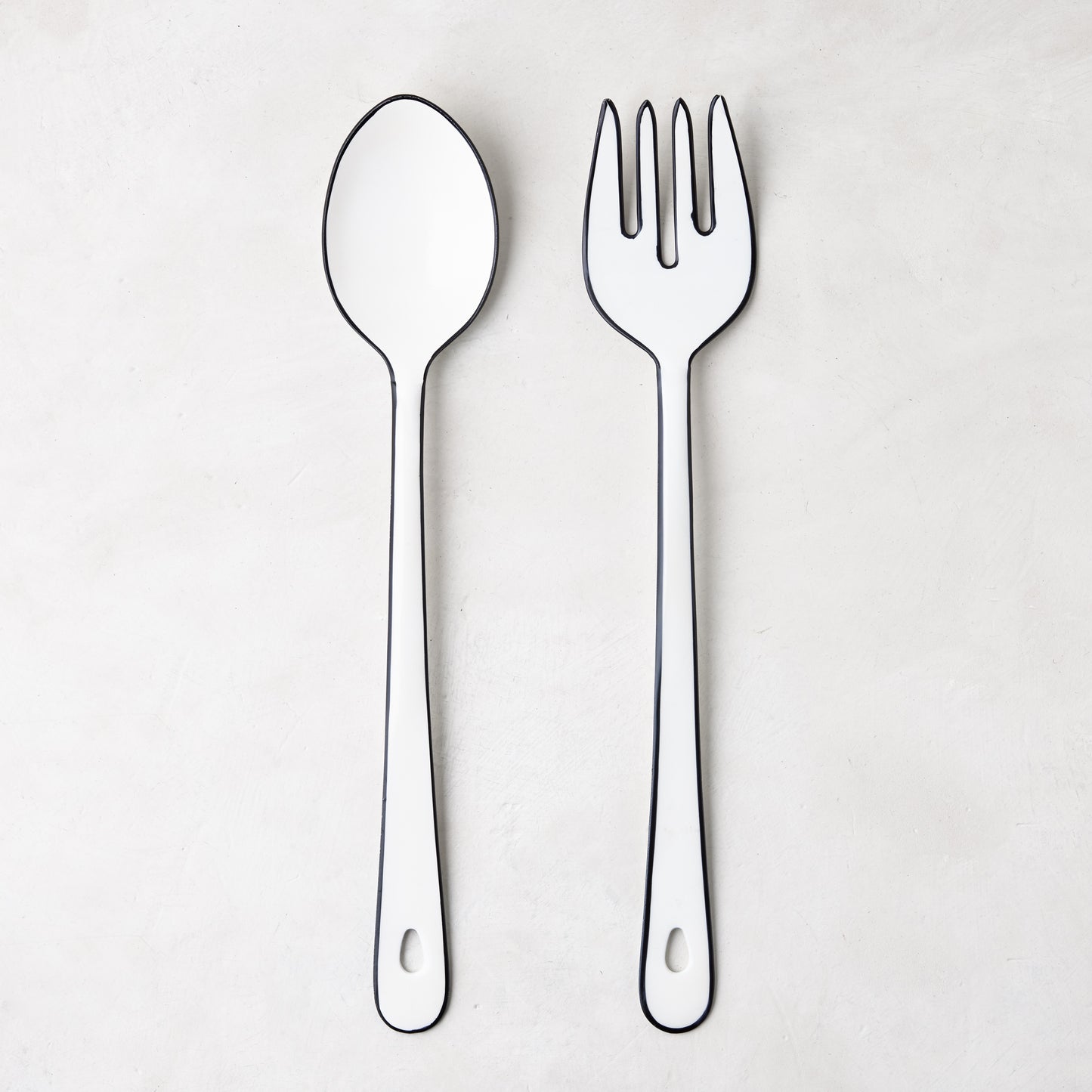 Diane Keaton + Hudson Grace white enamel serving spoon and fork with black borders.