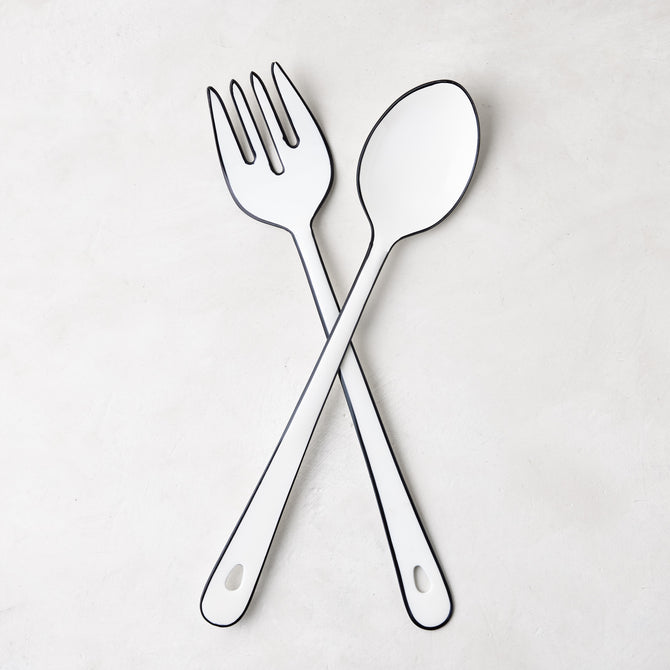 Diane Keaton + Hudson Grace white enamel serving fork and spoon with black borders, crossed.