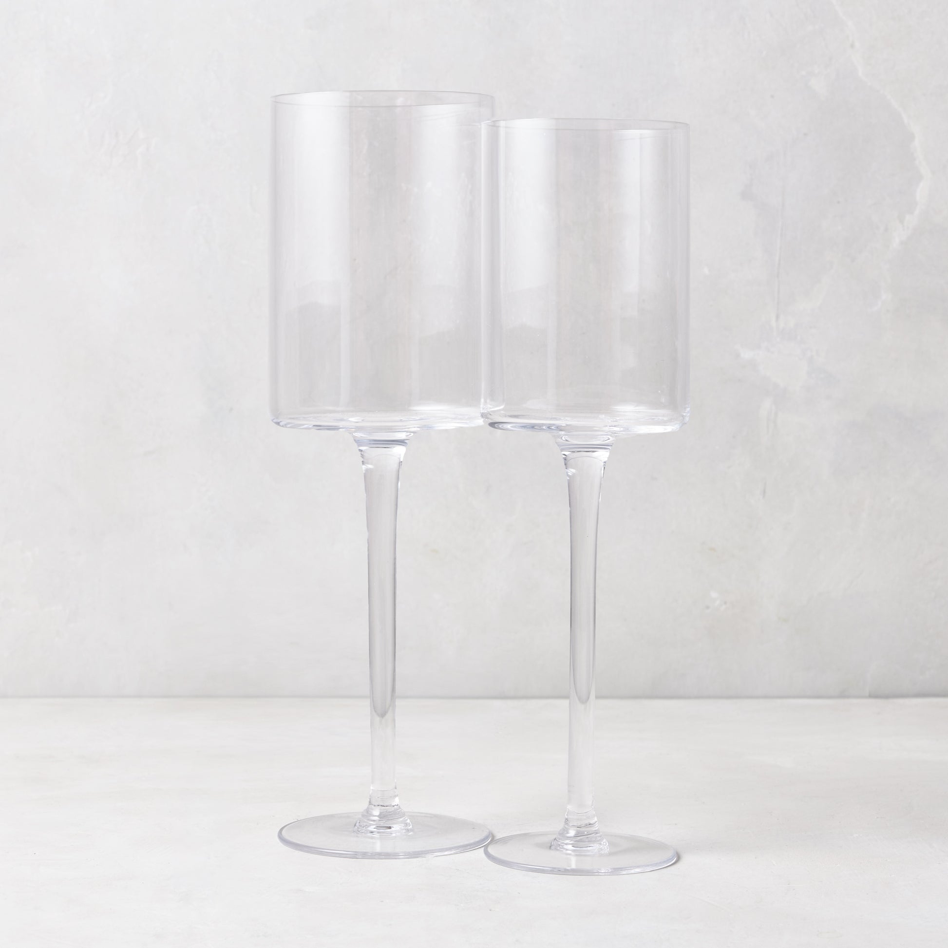 Two clear, tall Diane Keaton + Hudson Grace High Rise wine glasses, one large and one smaller.