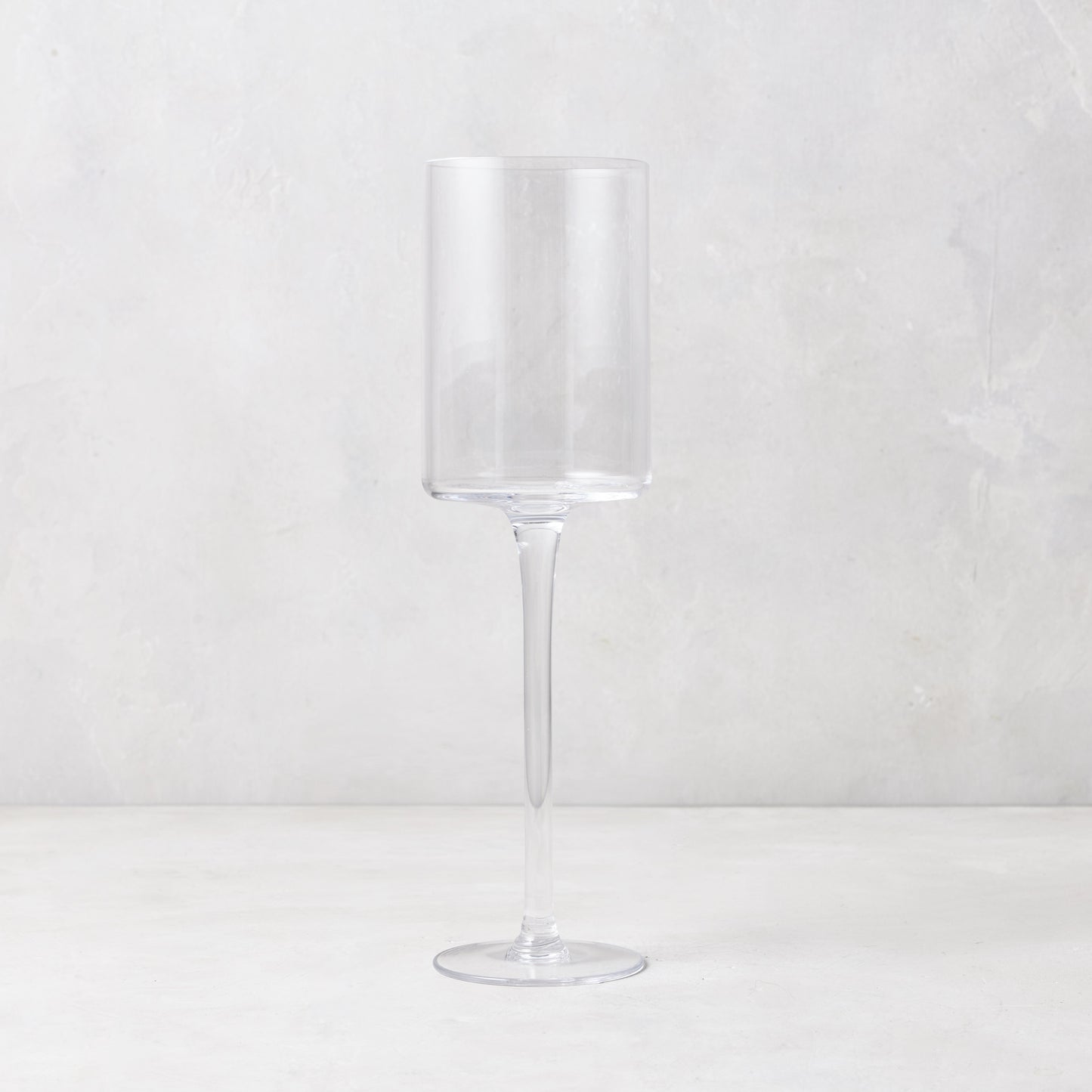 Clear, tall, straight-sided Diane Keaton + Hudson Grace High Rise Small Wine Glass on a white surface.