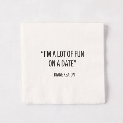 White 5.5" square paper cocktail napkin with "I'M A LOT OF FUN ON A DATE" - DIANE KEATON quote.