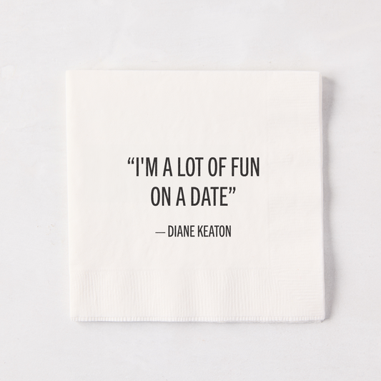 White 5.5" square paper cocktail napkin with "I'M A LOT OF FUN ON A DATE" - DIANE KEATON quote.
