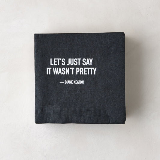 Black 5.5" square paper cocktail napkin with white "LET'S JUST SAY IT WASN'T PRETTY - DIANE KEATON" quote.
